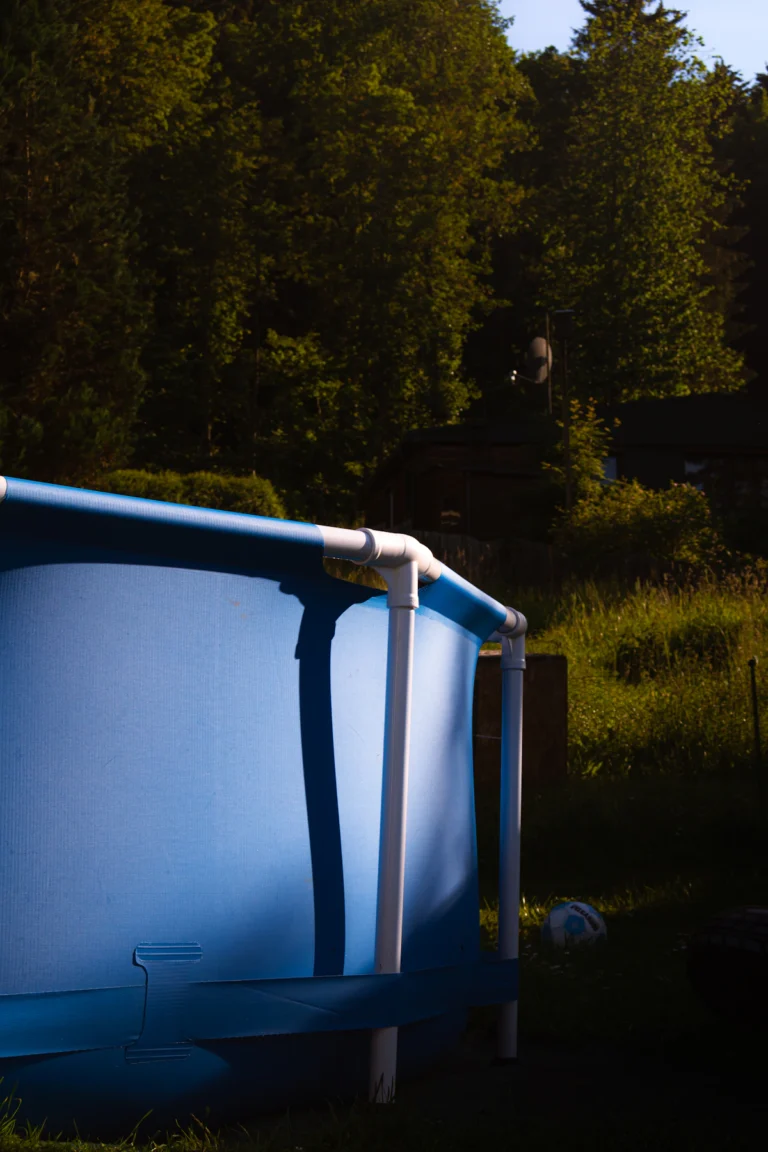 Above-ground pool in a backyard being maintained