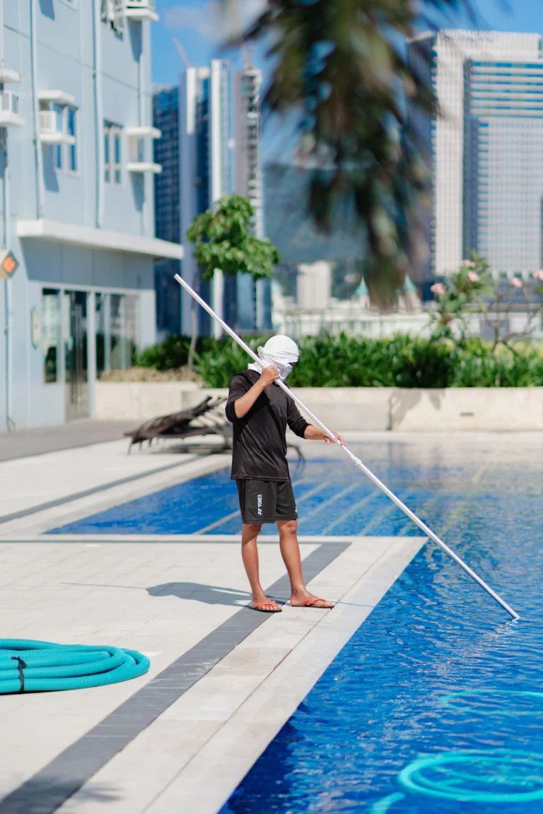 Pool service technician cleaning a pool on a scheduled visit